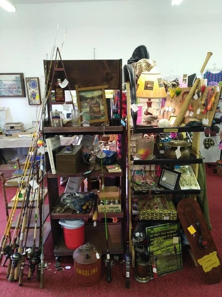 Antique shop shelves with fishing rods, artwork and vintage items